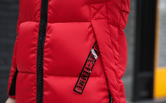 El nuevo abrigo largo de invierno acolchado de algodón para niñas, ajuste delgado, cuello de piel coreano, relleno de plumas, grueso, para mujer.