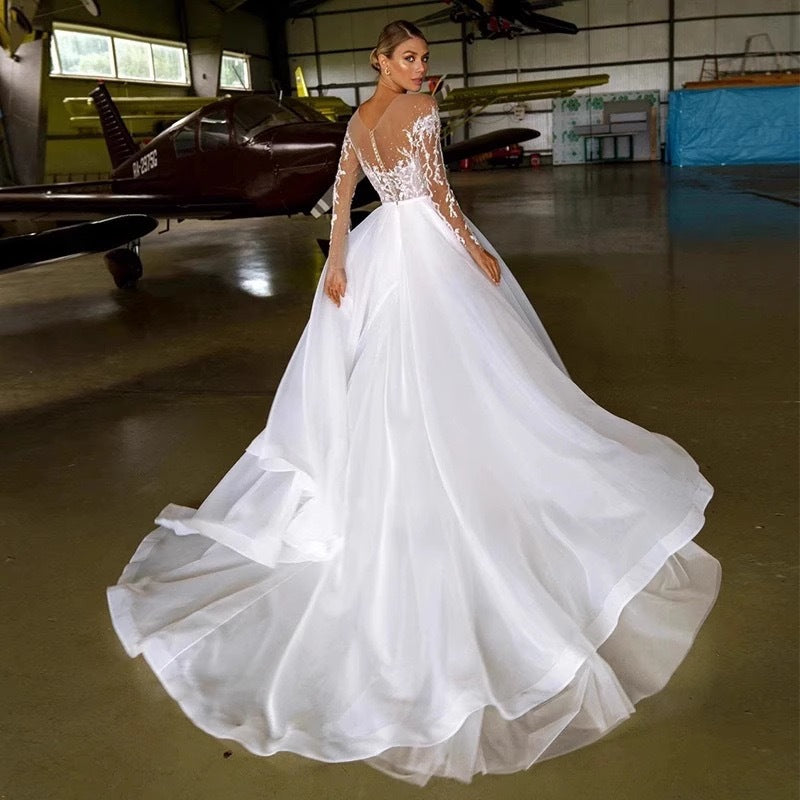 Vestido de novia con mangas largas bordadas y hombros descubiertos