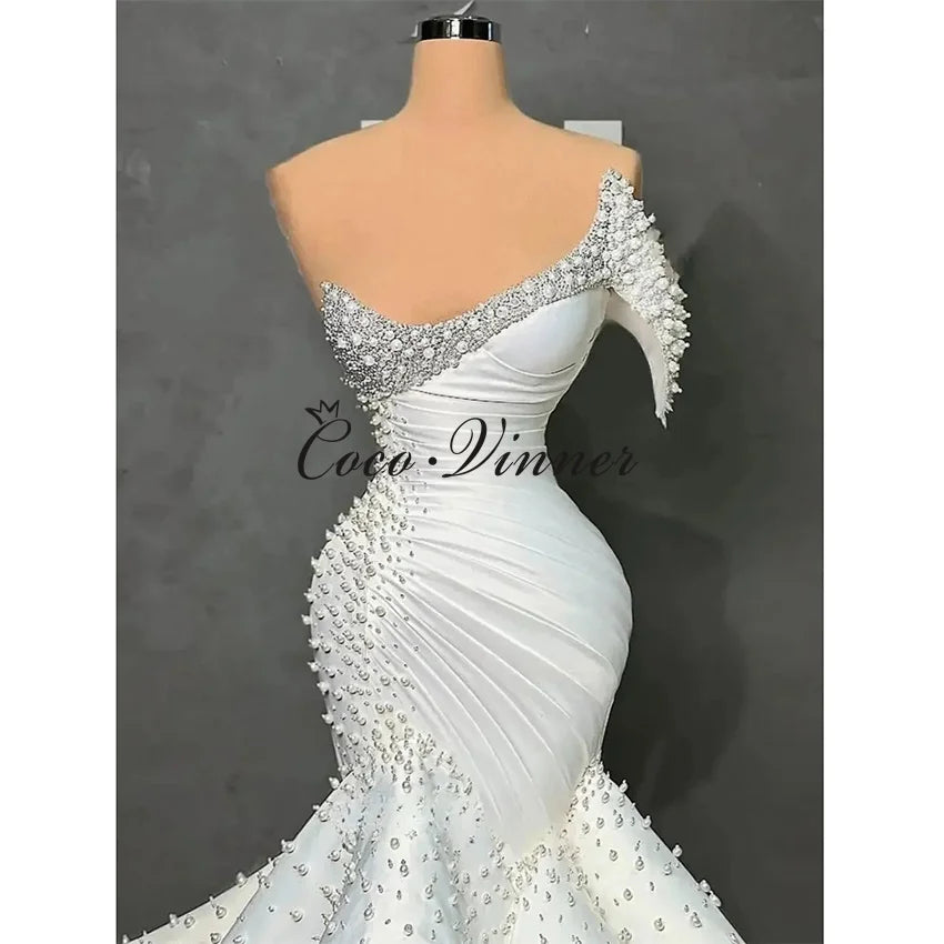 Customized One Shoulder Sleeveless Luxury Mermaid Wedding Dresses 2026 Pearls Beading On Satin Ruffle Wedding Dress Africa W1550